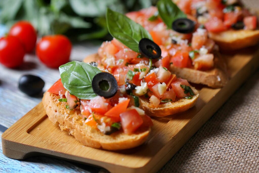 Bruschetta z pomidorami i oliwą extra virgin na drewnianej desce