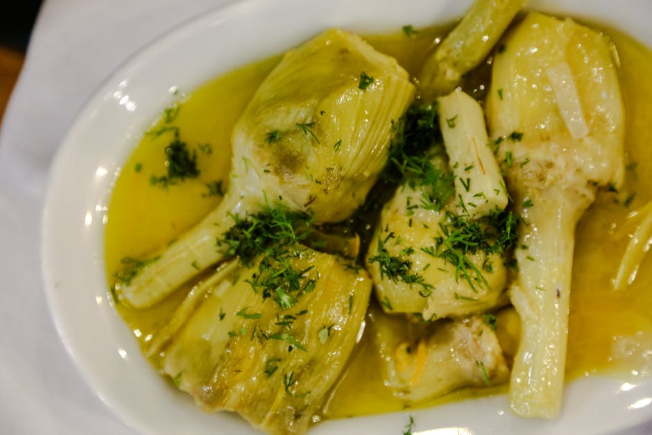 A mouthwatering plate of artichokes drizzled in olive oil and herbs, perfect for food lovers.