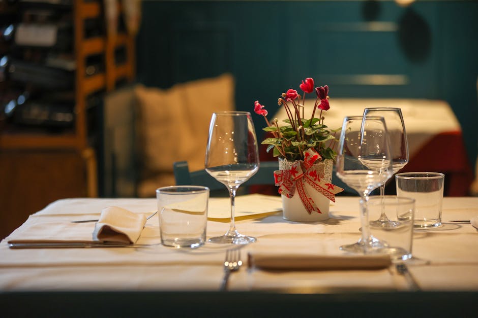 Elegant table setting in a Venetian restaurant with glassware, napkins, and floral centerpiece.