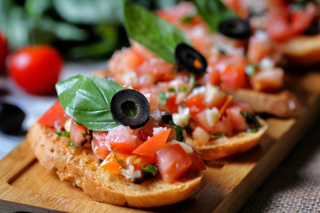 Bruschetta z oliwą extra vergine i pomidorami na drewnianej desce